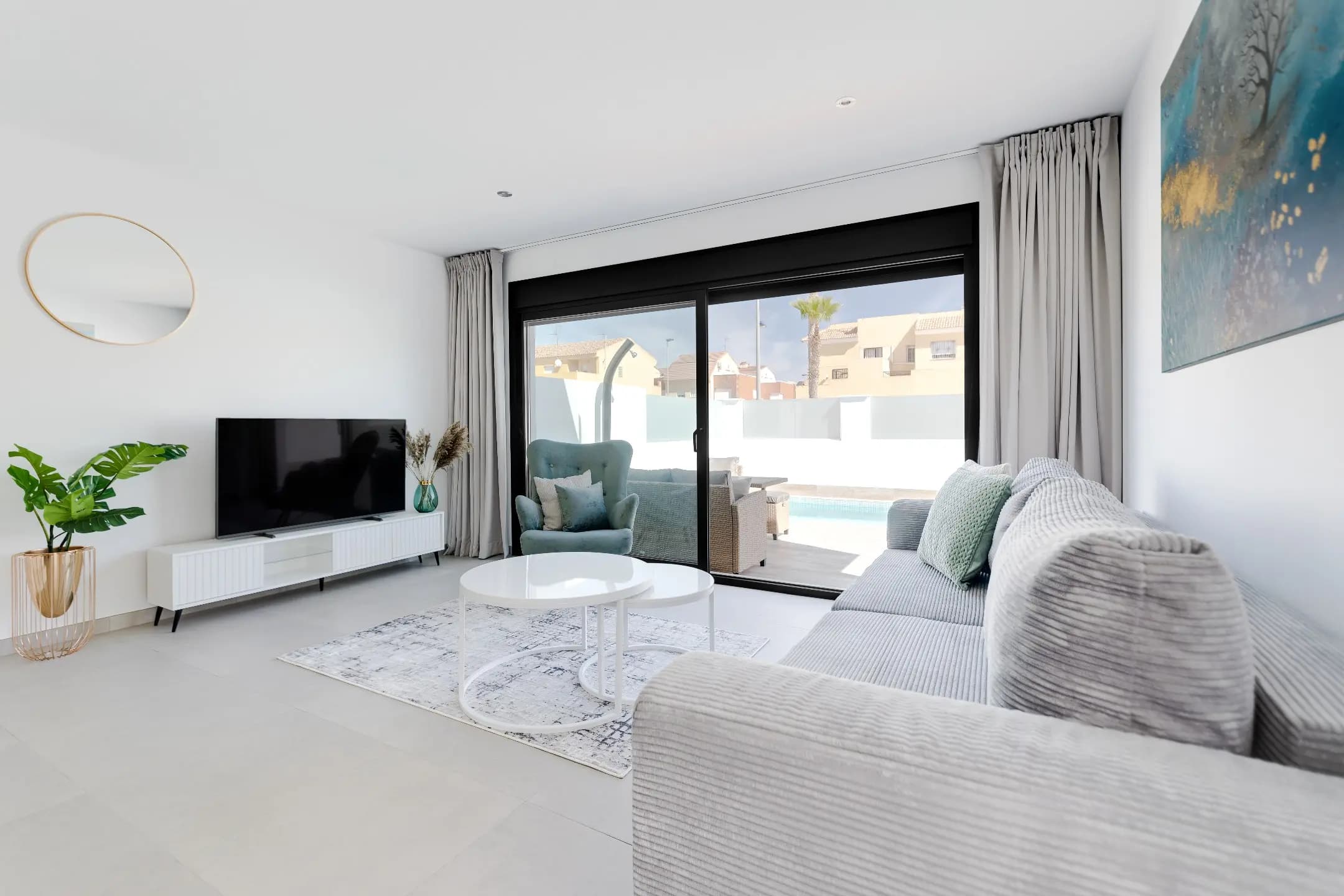 A modern living room with white walls and a large television