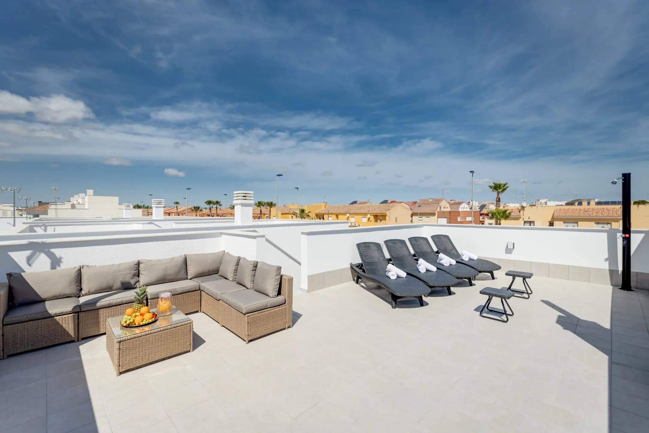 Rooftop patio with lounge chairs and table, perfect for relaxing outdoors.